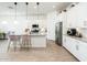 Contemporary kitchen with stainless steel appliances, white cabinetry, and a stylish island at 17054 W Saguaro Park Ln, Surprise, AZ 85387
