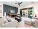 Open-concept living room with stylish furnishings and a sliding door leading to a covered patio at 17054 W Saguaro Park Ln, Surprise, AZ 85387