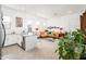 Open living space featuring white cabinets, island and an adjacent sitting area with a bright yellow couch at 17054 W Saguaro Park Ln, Surprise, AZ 85387