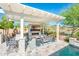 Outdoor living space with seating area, a fireplace, and a poolside pergola for relaxing and entertaining at 17054 W Saguaro Park Ln, Surprise, AZ 85387