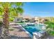 Sparkling pool with sunshade and outdoor dining area amidst tropical landscaping at 17054 W Saguaro Park Ln, Surprise, AZ 85387