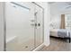 Modern glass-enclosed shower with tile surround, bench, and modern fixtures at 17054 W Saguaro Park Ln, Surprise, AZ 85387