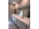 Bathroom with double sink vanity with white countertop, neutral walls, and a large mirror at 18225 W Larkspur Dr, Goodyear, AZ 85338