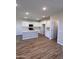 Modern kitchen with white cabinets, stainless steel appliances, a kitchen island and wood-look flooring at 18225 W Larkspur Dr, Goodyear, AZ 85338