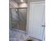 Bright bathroom featuring a glass enclosed shower with marble style wall tiling and dark floor tiles at 18225 W Larkspur Dr, Goodyear, AZ 85338