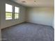 A light and airy empty bedroom with two large windows and soft gray carpet at 1984 E Bucking Bronco Dr, San Tan Valley, AZ 85140