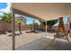 Covered patio with a relaxing swing and desert landscaping and cute little palm trees at 20501 N 93Rd Ave, Peoria, AZ 85382