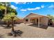 View of the home's backyard featuring a covered patio with a porch swing, desert landscaping, and blue skies at 20501 N 93Rd Ave, Peoria, AZ 85382