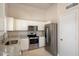 Well-lit kitchen boasts white cabinetry, granite counters, stainless steel appliances and tile flooring at 20501 N 93Rd Ave, Peoria, AZ 85382
