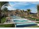 Resort-style community pool with lounge chairs, umbrellas, palm trees, and mountain views at 20793 W San Miguel Ave, Buckeye, AZ 85396