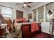 Bedroom features traditional southwest decor, wood blinds, ceiling fan, and natural light at 20839 E Kingbird Dr, Queen Creek, AZ 85142