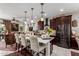 Modern kitchen island with seating, stylish pendant lights, and stainless steel appliances, open to the living area at 20839 E Kingbird Dr, Queen Creek, AZ 85142
