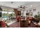 Elegant living room with leather sofa, chandelier, and large sliding doors showcasing a beautiful backyard and pool at 20839 E Kingbird Dr, Queen Creek, AZ 85142