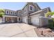 Spacious home showcasing a three-car garage and inviting front porch, perfect for suburban living at 21147 E Via Del Oro --, Queen Creek, AZ 85142