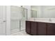 Bathroom featuring double sinks, dark wood cabinets and glass shower at 21412 W Hubbell St, Buckeye, AZ 85396