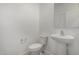 Small half bathroom with white walls, pedestal sink and elongated toilet at 21412 W Hubbell St, Buckeye, AZ 85396