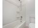 A white bathtub and shower combo with modern fixtures complemented by a toilet in a bright bathroom at 21412 W Hubbell St, Buckeye, AZ 85396