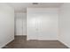A simple bedroom with a carpeted floor, white walls, and two doors, offering a blank canvas at 21412 W Hubbell St, Buckeye, AZ 85396