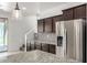 Kitchen with stainless refrigerator, dark cabinets, tile backsplash and beautiful granite countertops at 21412 W Hubbell St, Buckeye, AZ 85396