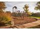 Community playground featuring climbing structures and a soft landing surface, surrounded by green space at 21564 W Pierson St, Buckeye, AZ 85396
