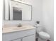 Neutral toned half bathroom with white cabinet, mirror, toilet, and sink at 2232 W Lindner Ave # 20, Mesa, AZ 85202