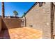 Private patio area with tiled floor, stucco walls, and access to outdoor space with palm trees at 2232 W Lindner Ave # 20, Mesa, AZ 85202