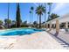 Community pool with clear blue water, lounge chairs, shade structures, and lush palm trees at 2232 W Lindner Ave # 20, Mesa, AZ 85202