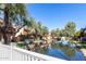 Scenic view of the community waterway, lush landscaping, and residences in the background at 2232 W Lindner Ave # 20, Mesa, AZ 85202