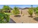 Backyard showcasing tasteful gravel landscaping with a tree, complemented by lush greenery and blooming plants at 22472 E Sonoqui Blvd, Queen Creek, AZ 85142