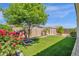 Lush backyard featuring artificial turf, mature shade tree, and vibrant rose bushes at 22472 E Sonoqui Blvd, Queen Creek, AZ 85142