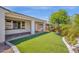 Inviting backyard with lush artificial turf, mature tree, and a covered patio area at 22472 E Sonoqui Blvd, Queen Creek, AZ 85142