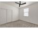 Bright bedroom with a ceiling fan, closet, and large window at 22472 E Sonoqui Blvd, Queen Creek, AZ 85142