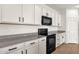 Modern kitchen features granite countertops, sleek black appliances, and stylish white cabinets at 22472 E Sonoqui Blvd, Queen Creek, AZ 85142