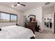 Bedroom featuring a ceiling fan, window, dresser and an open view of other rooms at 2458 N Abbey Rd, Casa Grande, AZ 85122