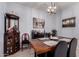 Formal dining room featuring rustic wood table and contemporary light fixture at 2458 N Abbey Rd, Casa Grande, AZ 85122