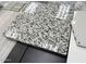 Close-up of a speckled gray and white granite countertop sample with tile and cabinet samples at 2458 N Abbey Rd, Casa Grande, AZ 85122