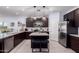 Modern kitchen with stainless steel appliances, an island with seating, and sleek cabinets at 2458 N Abbey Rd, Casa Grande, AZ 85122