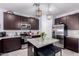 Beautiful kitchen features dark cabinets, stainless steel appliances, and a large center island with bar seating at 2458 N Abbey Rd, Casa Grande, AZ 85122
