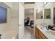 Bright bathroom with double sinks, tile flooring, bathtub, and view into bedroom at 3015 S Woodruff Dr, Mesa, AZ 85212