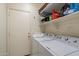 Bright laundry room with white washer and dryer and wire shelving at 3015 S Woodruff Dr, Mesa, AZ 85212