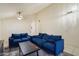 Open-concept living room featuring comfortable blue sofas, ceiling fan, and neutral decor at 3015 S Woodruff Dr, Mesa, AZ 85212