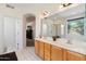 Bathroom with double sinks, arched doorway, tiled floor and a large mirror at 345 N Scott Dr, Chandler, AZ 85225