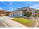 Beautiful home featuring a well-manicured lawn and colorful bushes by the front with a gray two-car garage at 345 N Scott Dr, Chandler, AZ 85225