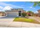 Gorgeous home showcasing a green lawn, decorative shrubs, and a stone-accented gray two-car garage at 345 N Scott Dr, Chandler, AZ 85225