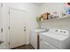 Well-lit laundry room with a white washer and dryer next to the door at 345 N Scott Dr, Chandler, AZ 85225
