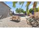 An inviting backyard offers a pool, brick pavers, picnic table, bicycles and lush green trees at 345 N Scott Dr, Chandler, AZ 85225