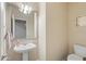 Charming powder room with a pedestal sink, toilet, decorative mirror and neutral tones at 345 N Scott Dr, Chandler, AZ 85225