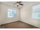 Bedroom featuring carpet flooring, neutral walls, two windows, and a ceiling fan at 3530 S Bandit Rd, Gilbert, AZ 85297