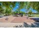 Community playground with slides and play equipment surrounded by mature trees and green space at 3530 S Bandit Rd, Gilbert, AZ 85297