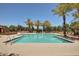 Sparkling community pool surrounded by palm trees, lounge chairs, and a gated fence for safety at 3530 S Bandit Rd, Gilbert, AZ 85297